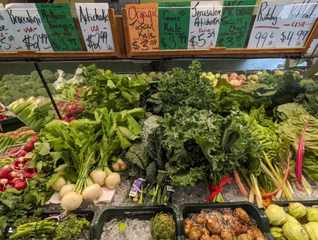 Fresh produce display at Golden Harvest — kale, artichokes, radishes, and more